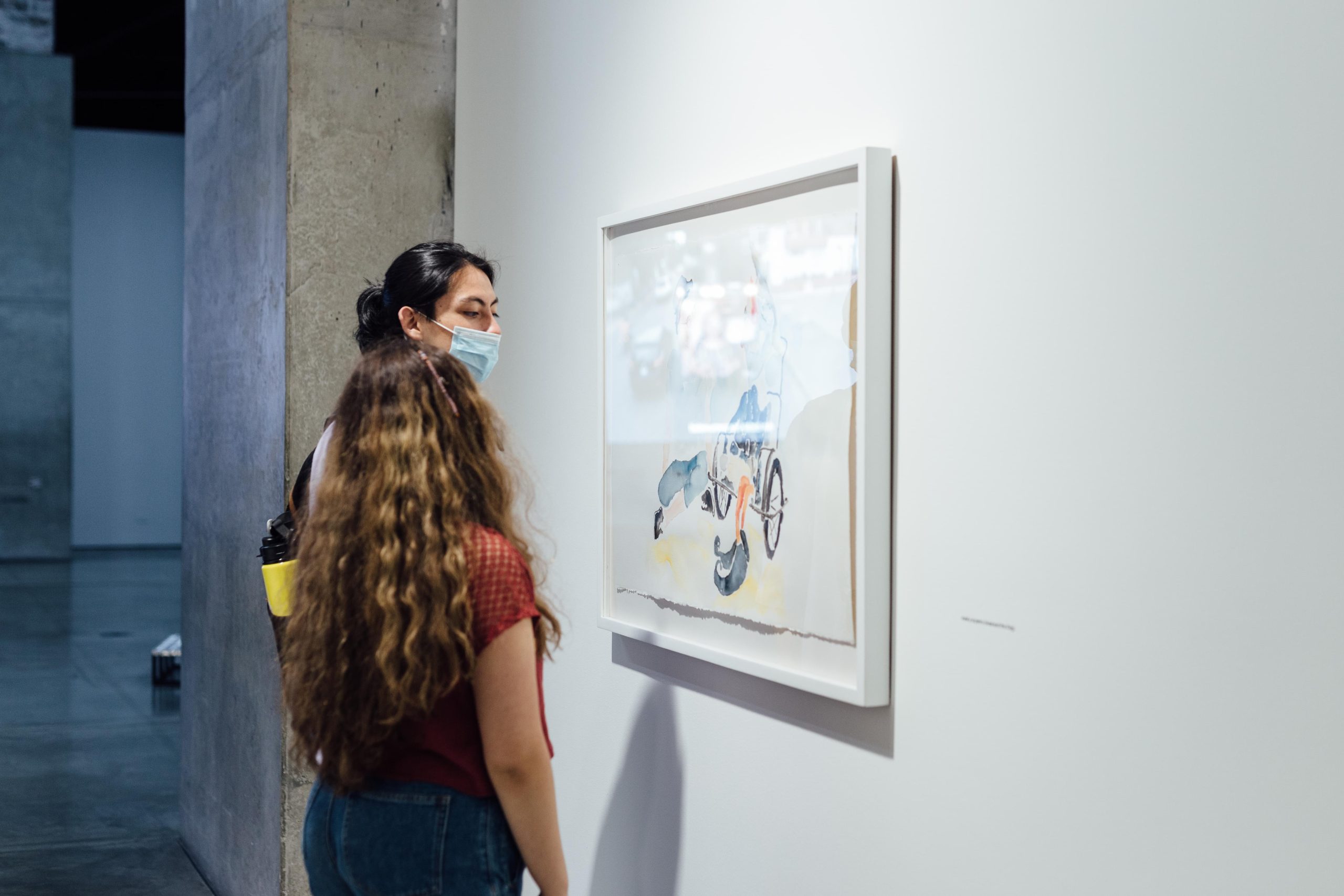 MAMM Exposiciones: dos mujeres jóvenes observan cuadro en trescaras, tres mundos