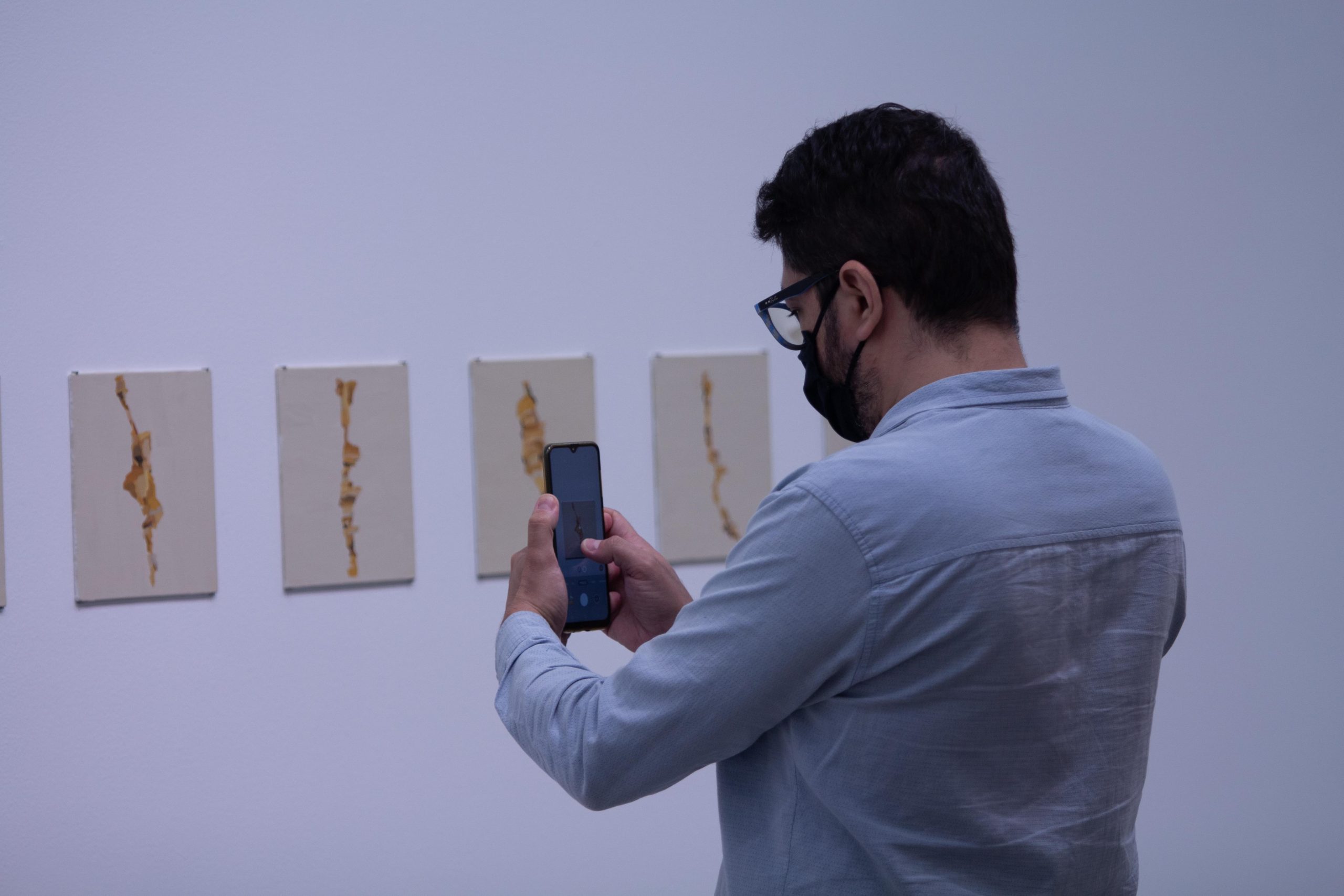 Exposiciones MAMM: hombre toma fotos a una de las piezas en Amarillos, obra de Irene Kopelman