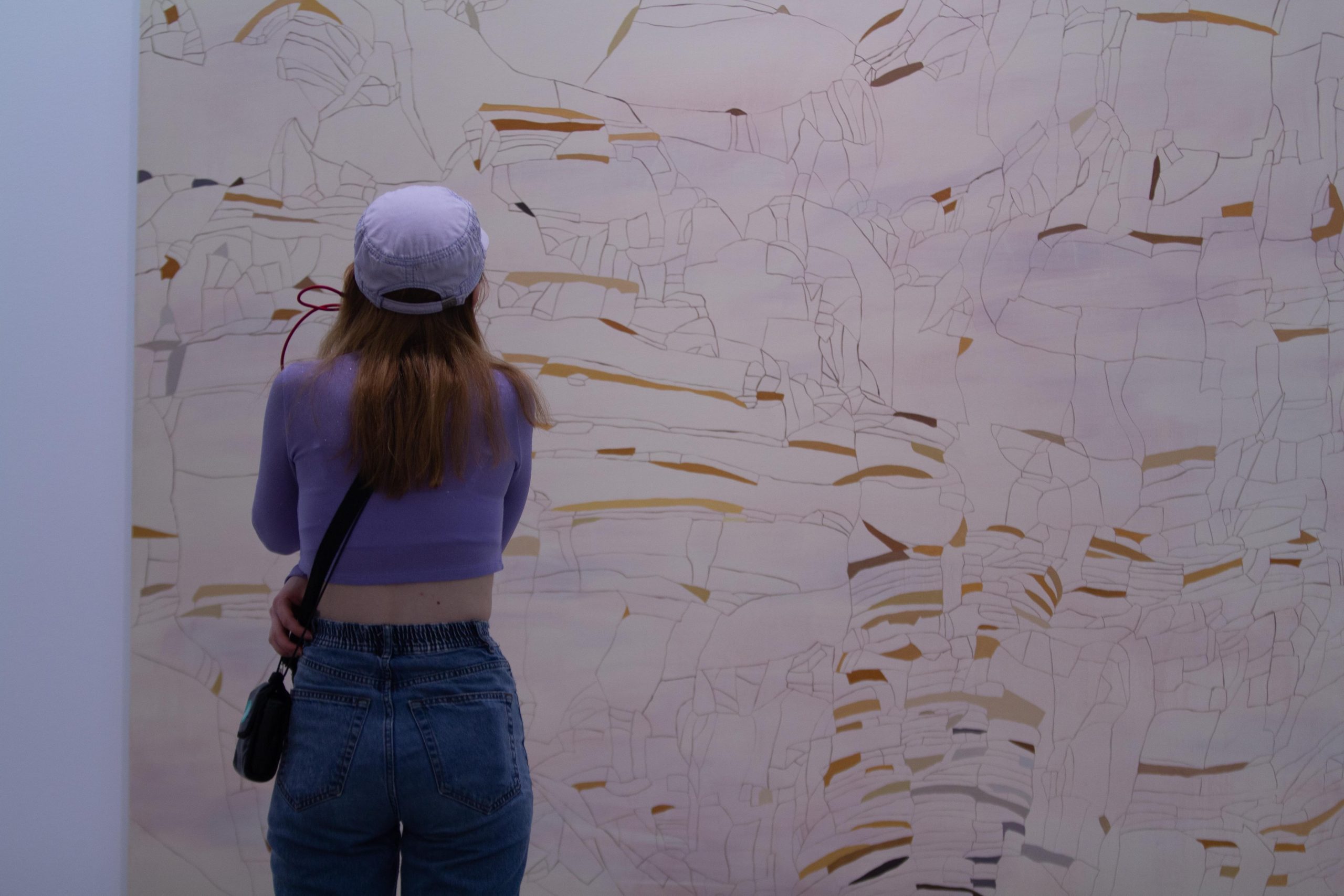 Exposiciones MAMM: mujer contempla una de las piezas en Amarillos, obra de Irene Kopelman