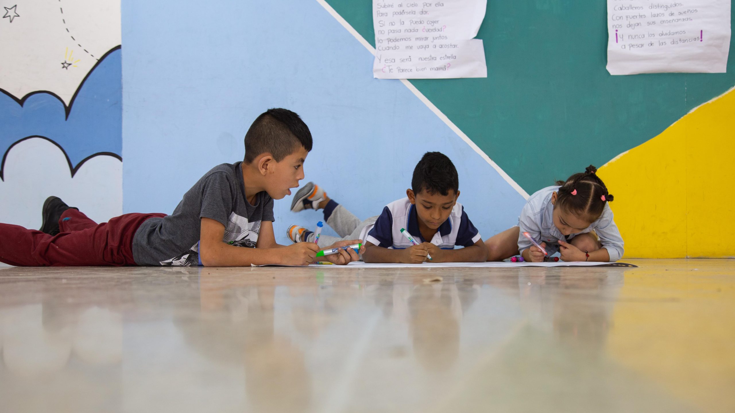 Niños coloreando en el piso