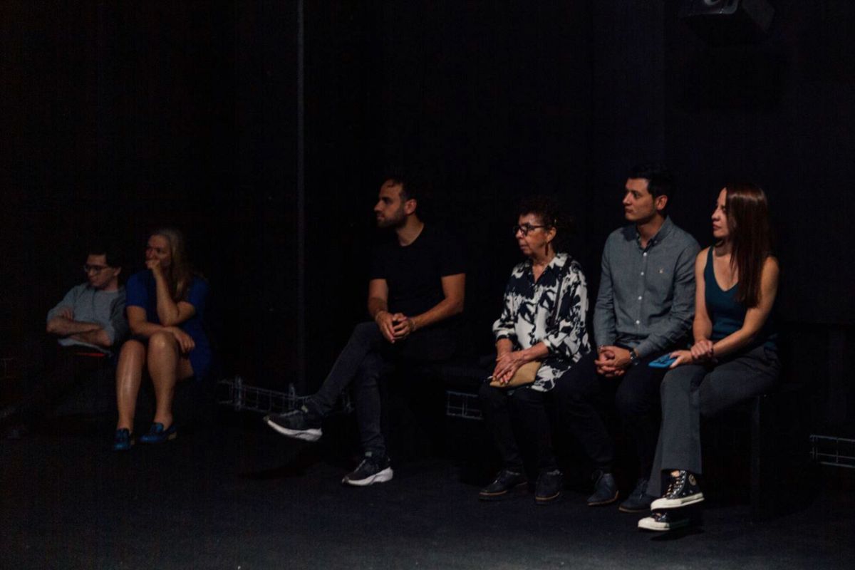 Personas sentadas en una sala de exposiciones