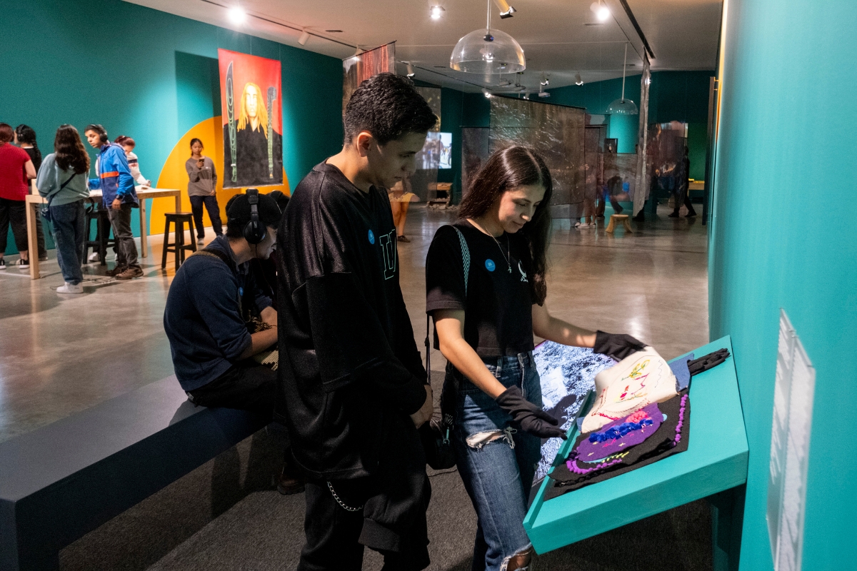 Fotografía de visitantes en la exposición Desafiar. Atravesar el sol desde el Pacífico