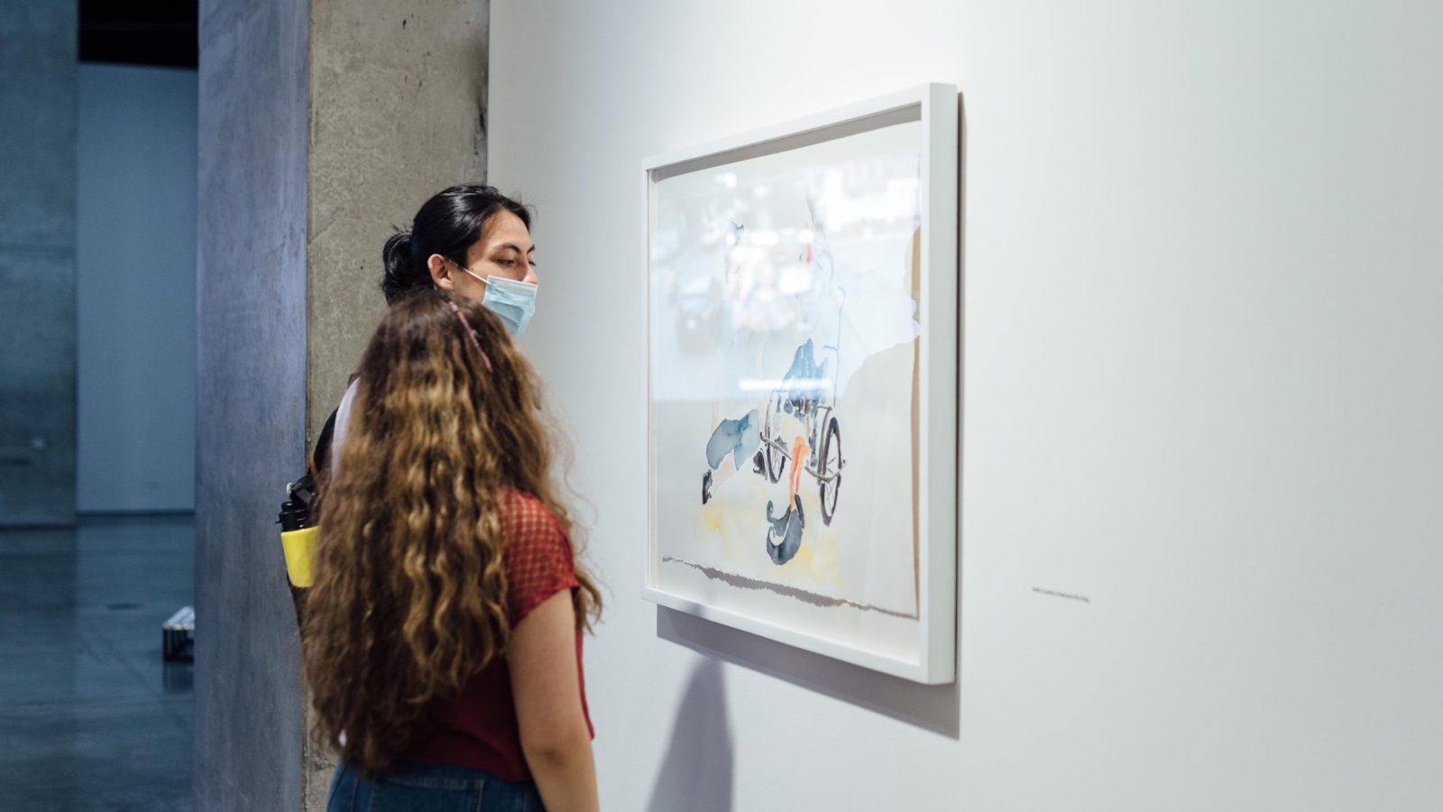 MAMM Exposiciones: dos mujeres jóvenes observan cuadro en trescaras, tres mundos