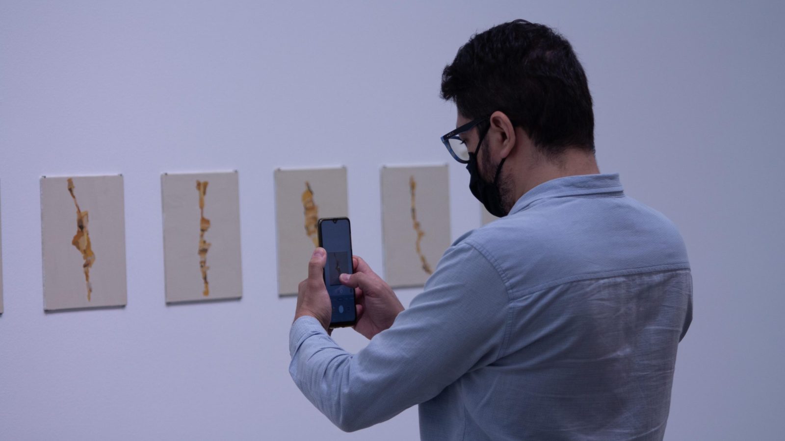 Exposiciones MAMM: hombre toma fotos a una de las piezas en Amarillos, obra de Irene Kopelman