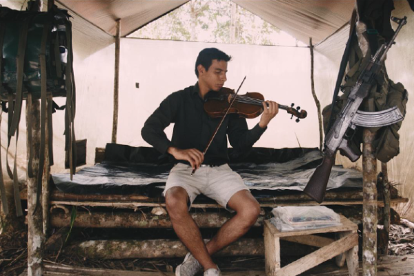 hombre tocando el violín en un campamento en la selva