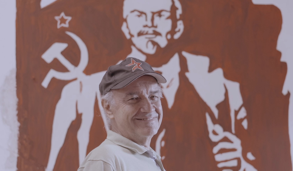 Hombre con imagen de Lenin a sus espaldas
