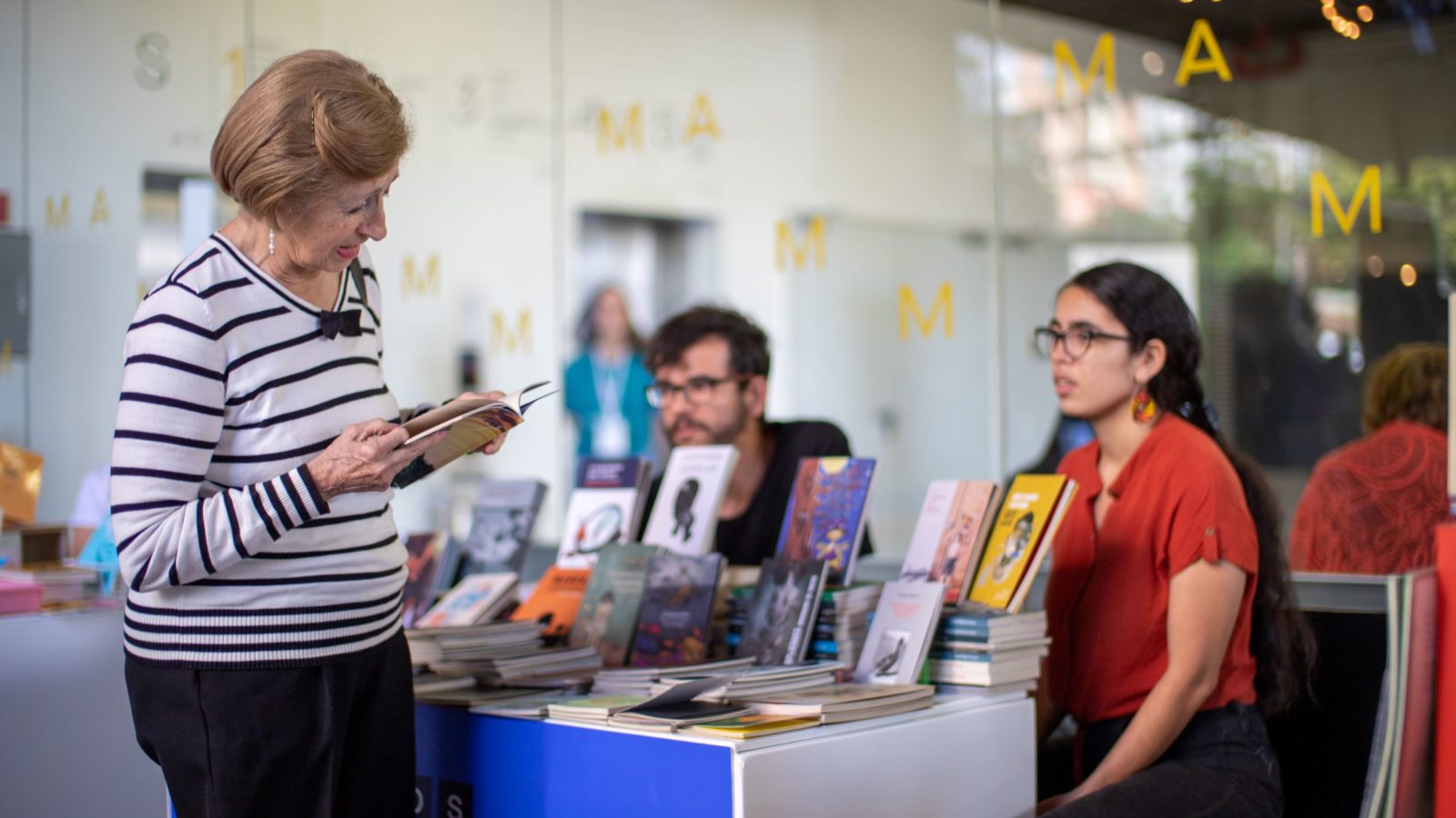 Mujer viendo los libros del Mercado de Editoriales independientes "Lo pequeño es ejemplar" del MAMM